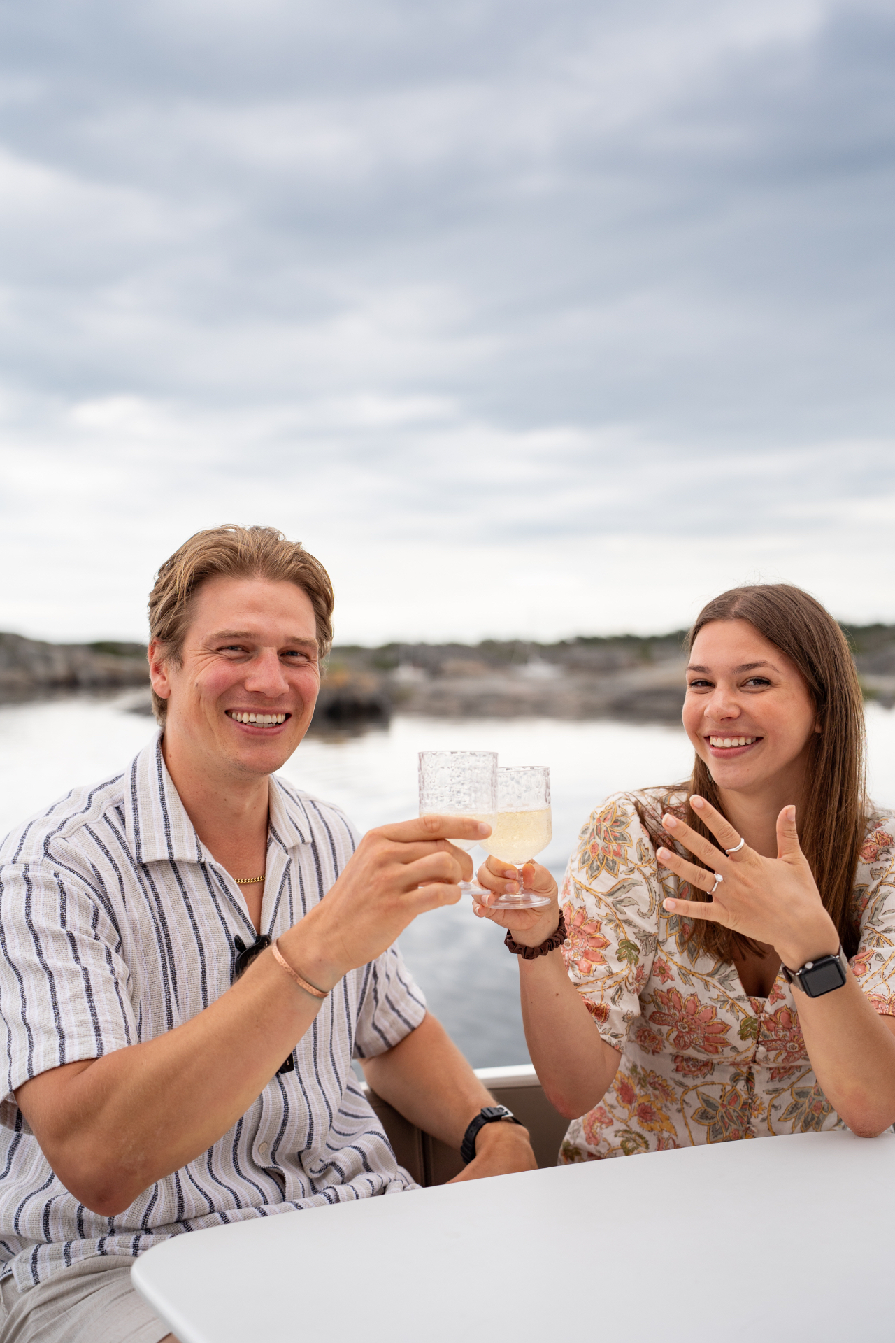 Couple raising a toast with champagne by the water in the Stockholm archipelago