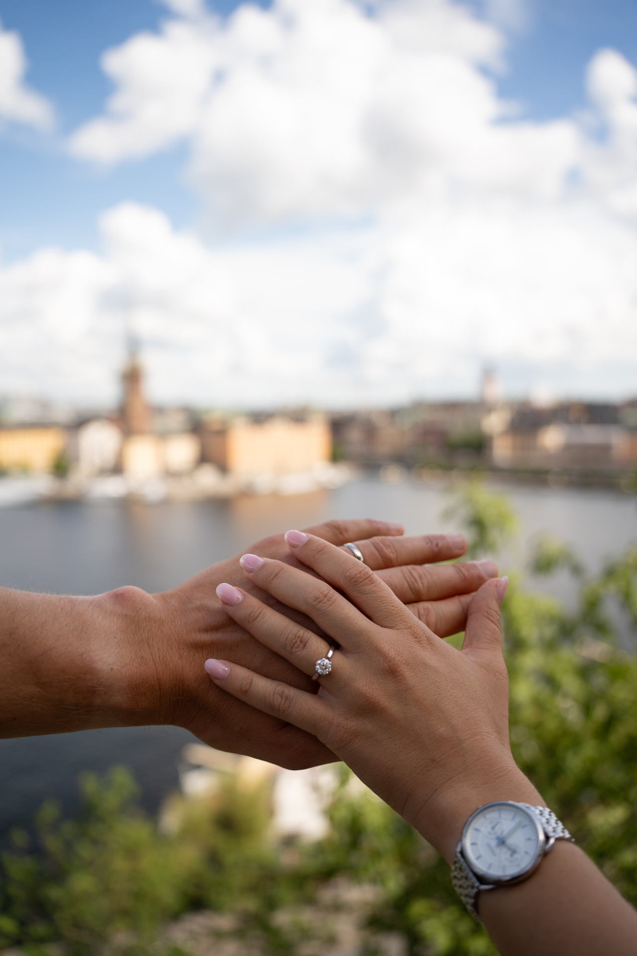 Engagement ring on a hand with Stockholm and the water in the background after a proposal on a boat